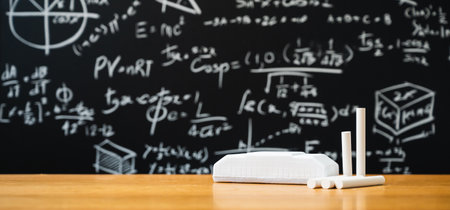 Education background concept. Board eraser and chalk on the wooden table with blackboard with many...