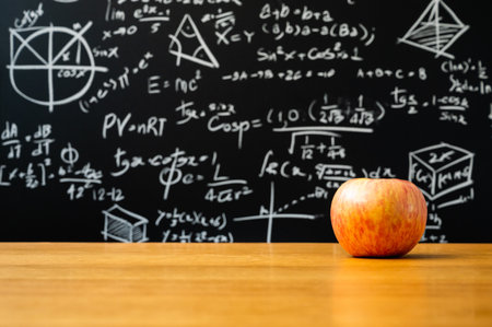 Apple on the woonden table desk in front of blackboard with the Mathematical formula. Education...