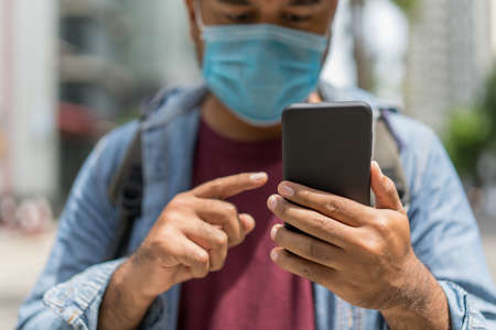 Young asian casual businessman wearing hat and protection mask standing on walkway airport terminal. Safety travel concept.の写真素材