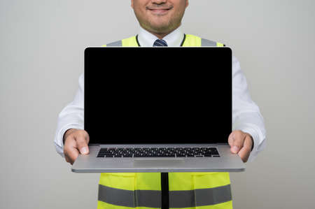 Civil engineer man showing blank screen laptop mockup for text advertise. Man with empty screen computer.の写真素材