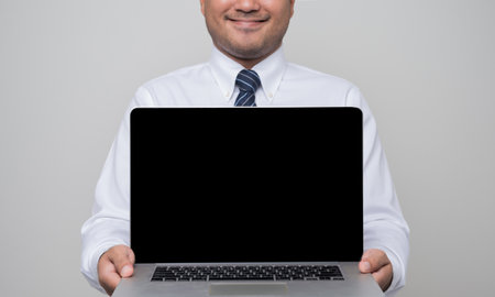 Businessman holding blank screen laptop showing in studio isolated white background.の写真素材