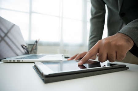 Close up male hands using tablet and laptop while work from home social distancing concept. Focusing...