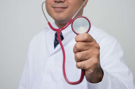 Close up Physician in white put stethoscope on ears and showing in front
camera isolated on white background.の写真素材