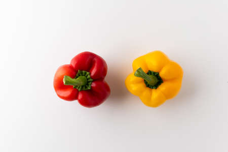 Raw red and yellow bell pepper on white table. Healthy vegetables and food.の写真素材
