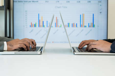 Two businessman using texting laptop computer on the business background.の写真素材