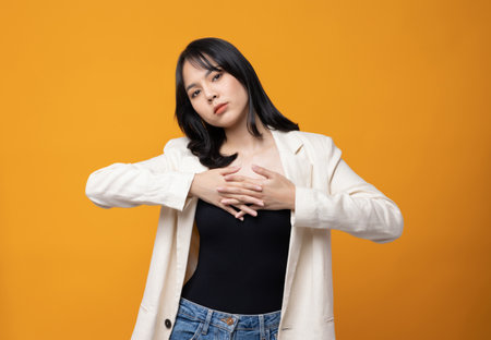 Attractive Beautiful asian woman standing and posing. Sexy female in suit on isolated yellow background.の写真素材