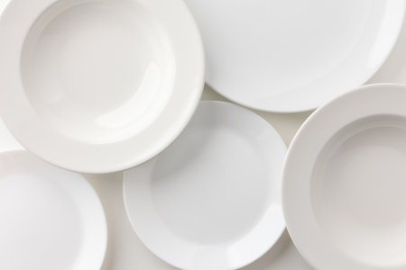 Several white plates arranged in a beautiful frame. There is a blank space to enter text.の写真素材