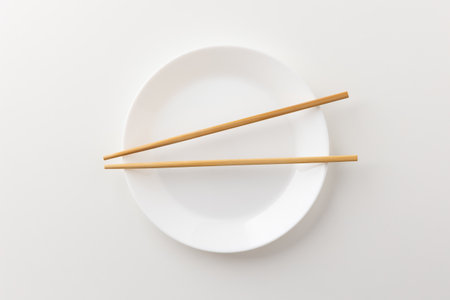 A white empty plate with chopsticks on the plateの写真素材