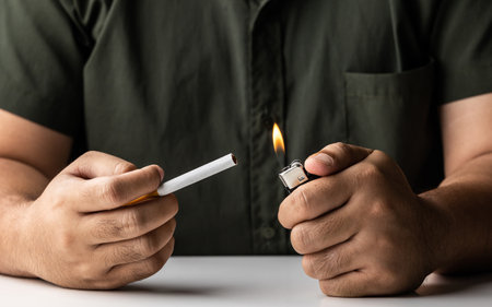 A young man with a cigarette He is going to smoke He lit the cigarette lighter with a lighter, and the smoke floated around.の写真素材