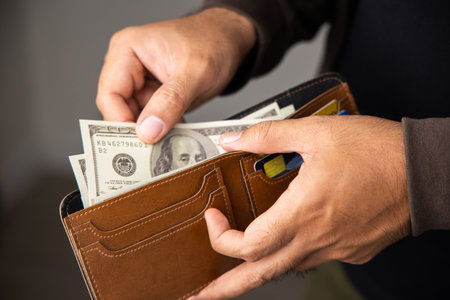 Close up male hand open the wallet.He has lot money us dollar in wallet. Financial business concept.
