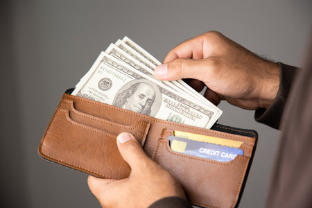 Close up male hand open the wallet.He has lot money us dollar in wallet. Financial business concept.の写真素材