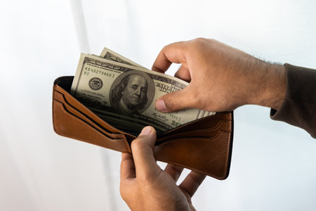 Close up male hand open the wallet.He has lot money us dollar in wallet. Financial business concept.の写真素材