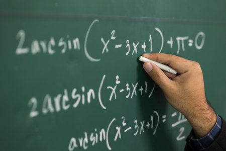 Education background concept. Close up male hand writing mathematical formula on chalkboard.の写真素材