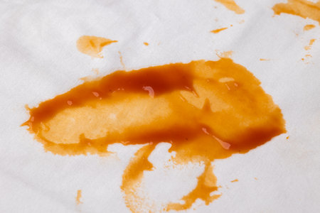 A white cotton shirt stained with ketchup. Must be washed thoroughly in the washing machineの写真素材
