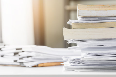 Piles of white papers work large piles of papers stacked together. On the desk in the office with...
