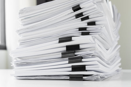 Piles of white papers work large piles of papers stacked together. On the desk in the office with...