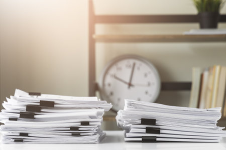 Piles of white papers work large piles of papers stacked together. On the desk in the office with...