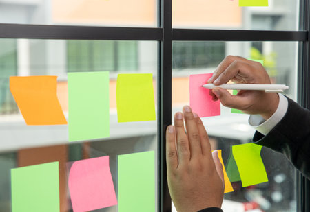 Business male writing note on the Colorful notes  on the wall. sticky note or paper note on the...