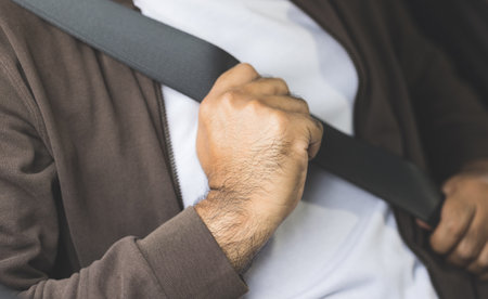 Young asian men getting new car and putting on his seat belt before driving car. Safety drive concept.の写真素材
