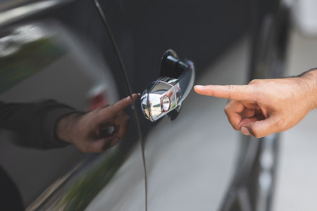 Close up male hand pushing keyless button hand grip car door to open the car door.