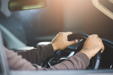The hand is holding the steering wheel of the car Safe drivingの写真素材