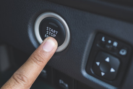 Fingers are pressing the car start button. Young man starting to drive a car.の写真素材