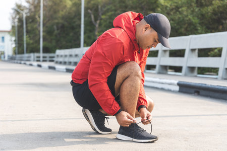 Runners tie their shoelaces prepared to run outdoors. Young asian man wearing sportswear running outdoor.Training athlete work out at outdoor concept.の写真素材