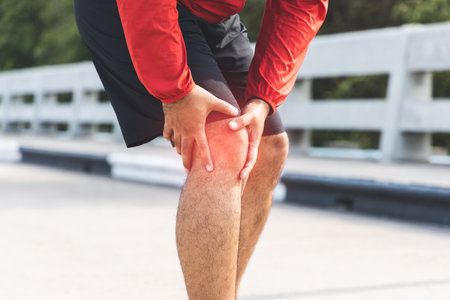 A runner has sore knees because he has been running for too long. Exercising until the injury....