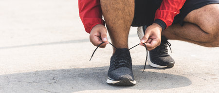 Runners tie their shoelaces prepared to run outdoors. Young asian man wearing sportswear running outdoor.Training athlete work out at outdoor concept.の写真素材
