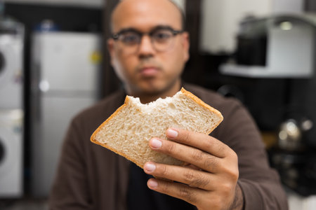 A young asian man eating breakfast Whole Wheat Bread Healthy breakfast It has good carbohydrates and vitamins. Fast food to eat in the morning before going to workの写真素材