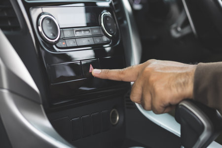 Close up male hand pressing emergency button in auto, stop by roadside, car accident.