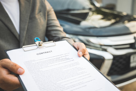 A young business man signs a luxury car leasing contract And sign a car insurance purchase contract on the documents according to the agreementの写真素材