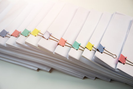 Piles of white papers work large piles of papers stacked together. On the desk in the office with...