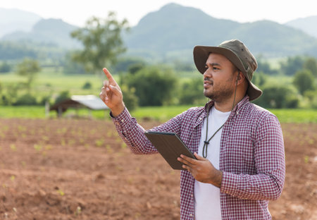 Smart farmer using a technology for studying and development agricultural. The farmer using tablet for tests the growth quality of seedling.の写真素材