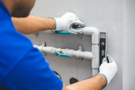 Male Plumber worker installation pipe system use spirit level for calculate. Plumbing checking service and repair.の写真素材