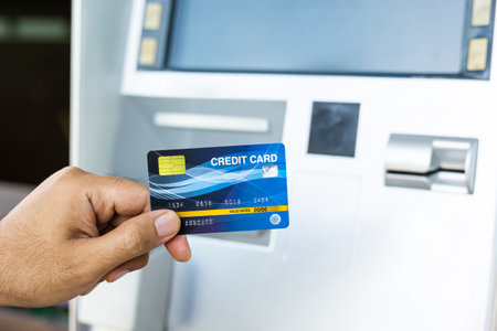 Close up male hand using credit To withdrawing Money from atm Machine. Man insert the atm card into...