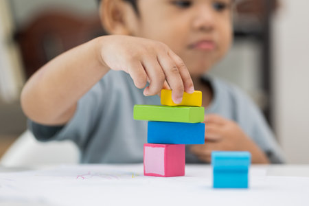 Close up Children hand Practice the skills of playing with wooden toys on the table in living room. Asian little boy education from home. Developing children's learning before entering kindergartenの写真素材