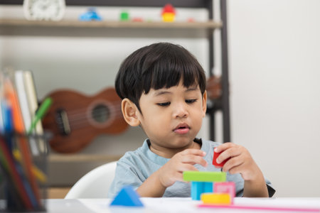 Asian little boy education from home. Developing children's learning before entering kindergarten Practice the skills of playing with wooden toys in living room.の写真素材