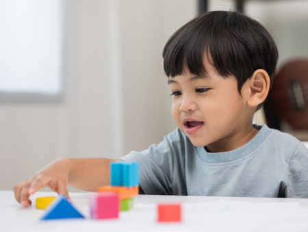Asian little boy education from home. Developing children's learning before entering kindergarten Practice the skills of playing with wooden toys in living room.の写真素材