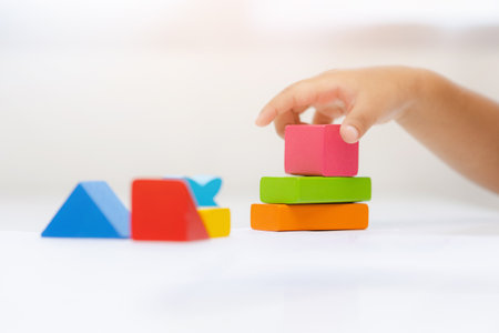 Close up Children hand Practice the skills of playing with wooden toys on the table in living room. Asian little boy education from home. Developing children's learning before entering kindergartenの写真素材