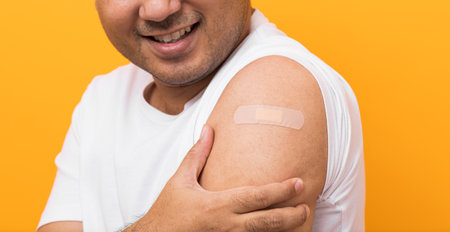 Vaccination campaign.Close up Young indian man getting coronavirus vaccine Immune and showing arm...