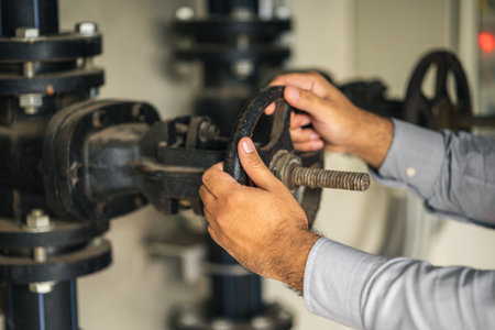 Young asian engineer working at valve water pump checking and maintenance for the safety. Worker...