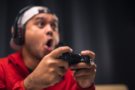 Close up male hands holding joystick game console. Young man playing video game online.の写真素材