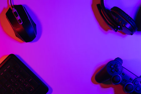 Accessory gaming keyboard joystick mouse headphone with blank space. Gadget for gamer playing video game online in the neon light darkroom.の写真素材