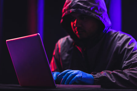 Hackers wear hoods to cover their faces. Hacking to steal important information. Use a computer to...