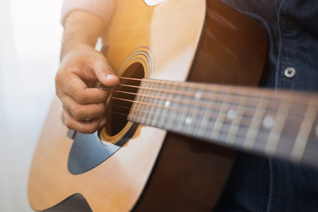Lifestyle concept. Young asian musician playing guitar in living room at home on this weekend....