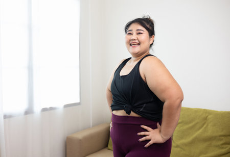 Smiling young asian women plus size standing pose looking camera. Happy lifestyle and proud herself. Sporty female in sportswear relaxing after workout.の写真素材
