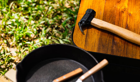 Hammer and camping accessory on wood table. Equipment for camping in forest. In summer with...