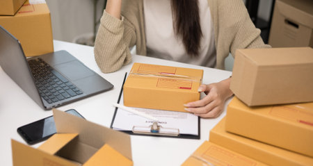 Close up Busy asian entrepreneur woman checking product on stock searching with laptop. Business...
