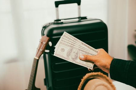 Close up traveler hand man getting many cash for travel in the trip. Trolley bag and Travel...